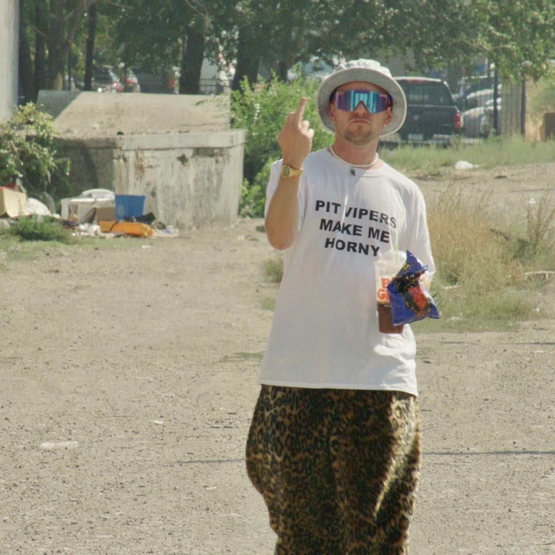 / Blue | A man flipping off the camera wearing Pit Viper Sunglasses