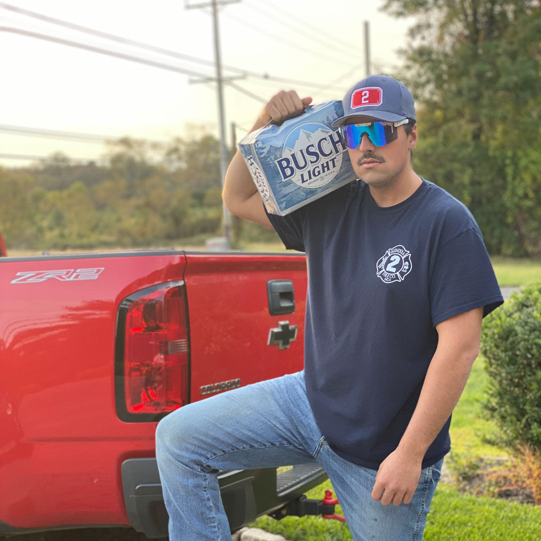 Narrow / Polarized Blue | Man holding a 12 pack of beer on his shoulders wearing The Merika Original from Pit Viper Sunglasses